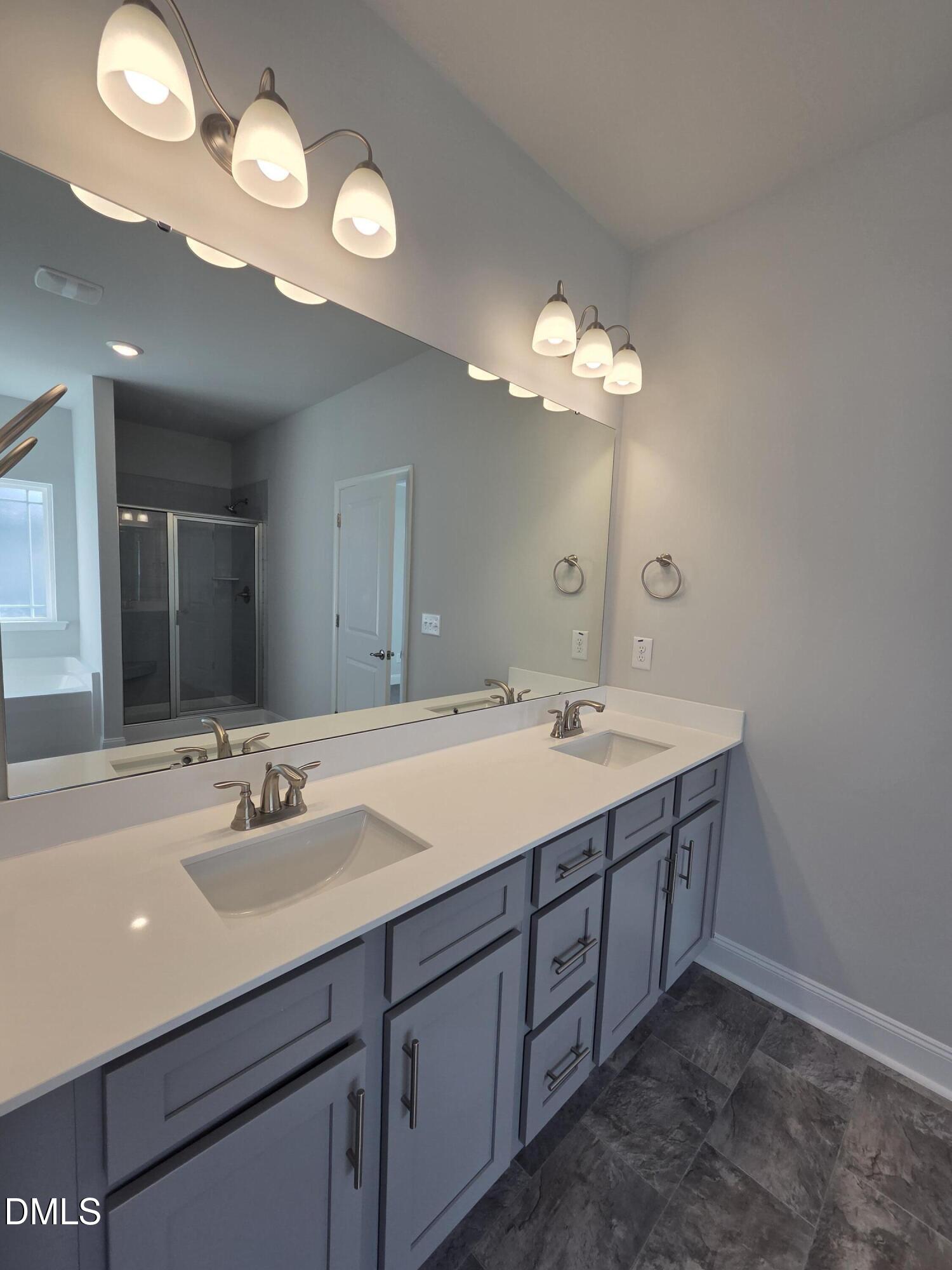 4979 Trident Maple Court Battleboro, NC 27809 - Photo 28 of 41 a bathroom with a double vanity sink and a mirror