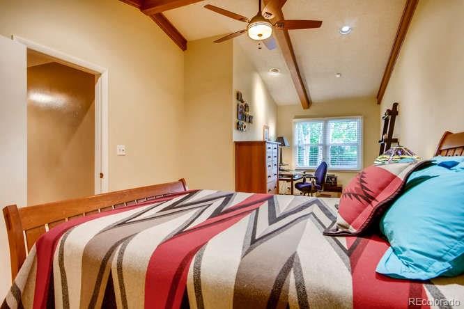 2917 Chase Street Wheat Ridge, CO 80214 - Photo 13 of 26 a bedroom with a bed and a chandelier