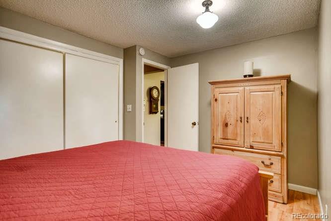 2917 Chase Street Wheat Ridge, CO 80214 - Photo 19 of 26 a bedroom with a large bed and a chandelier
