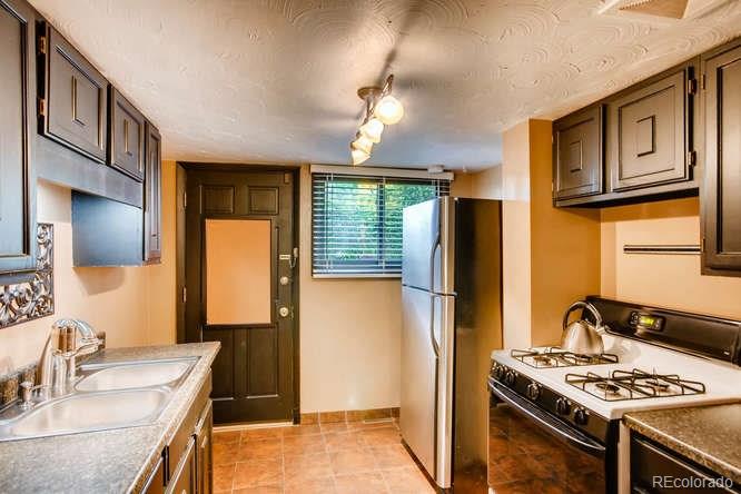 2917 Chase Street Wheat Ridge, CO 80214 - Photo 7 of 26 a kitchen with stainless steel appliances granite countertop a sink stove and refrigerator