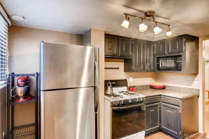 2917 Chase Street Wheat Ridge, CO 80214 - Photo 8 of 26 a kitchen with stainless steel appliances granite countertop a sink stove and refrigerator
