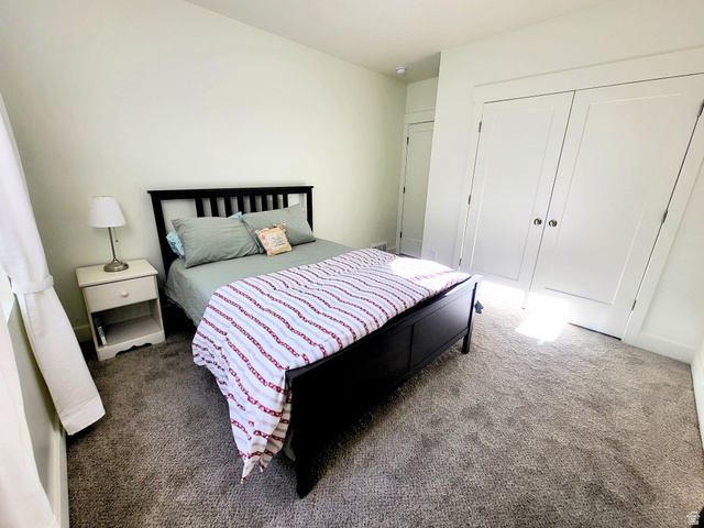683 Kings Landing Tooele, UT 84074 - Photo 21 of 39 Bedroom featuring light-toned walls, white trim, and a textured carpet