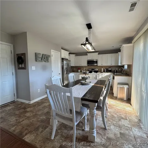 a kitchen with a table chairs refrigerator and cabinets