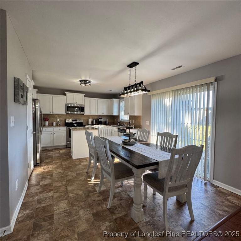 2020 Gray Goose Loop Fayetteville, NC 28306 - Photo 16 of 28 a view of a dining room with furniture and wooden floor