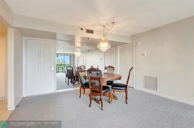 a view of a dining room with furniture and a chandelier