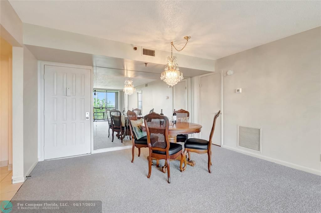 5260 Northwest 2nd Avenue, Unit 504 Boca Raton, FL 33487 - Photo 3 of 23 a view of a dining room with furniture and a chandelier