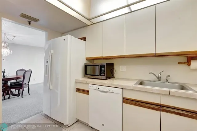 a kitchen with stainless steel appliances white cabinets and a refrigerator