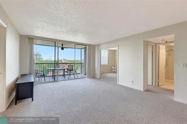 an empty room with furniture and a floor to ceiling window