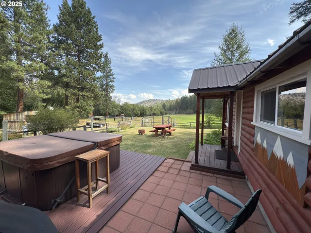 a view of a patio with table and chairs potted plants with wooden floor and fence