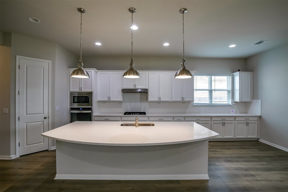 128 Ridgeview Court Georgetown, TX 78628 - Photo 6 of 22 a kitchen with kitchen island a sink stainless steel appliances and wooden floor
