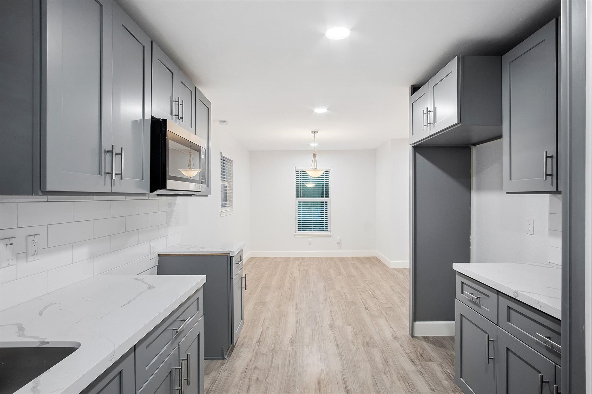 4808 Terry Street Houston, TX 77009 - Photo 13 of 21 a kitchen with a sink a microwave and cabinets