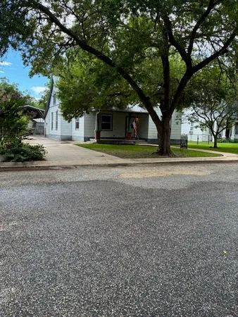 a front view of a house with a yard and an trees