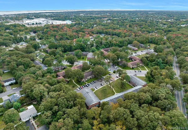 an aerial view of residential houses with outdoor space and trees