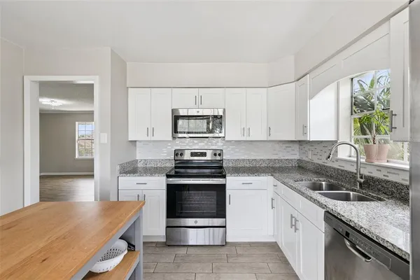 a kitchen with granite countertop a sink and a refrigerator