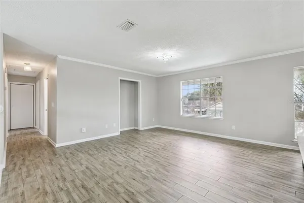 a view of an empty room with wooden floor