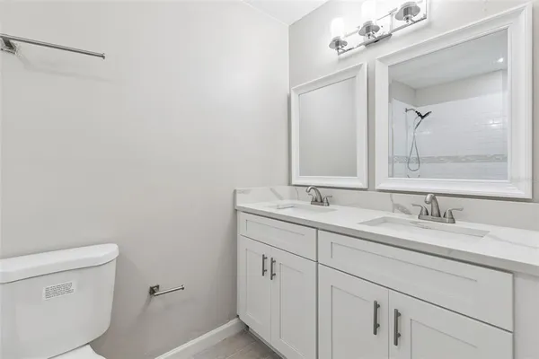 a bathroom with a granite countertop sink toilet and shower