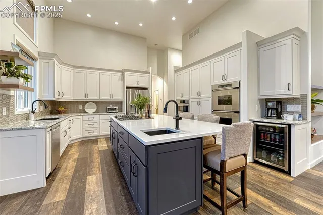 a kitchen that has a sink a stove and a refrigerator