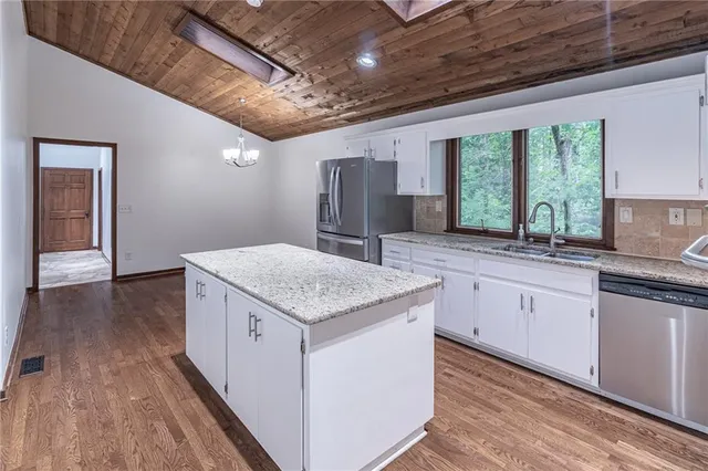 a kitchen with granite countertop a sink and cabinets
