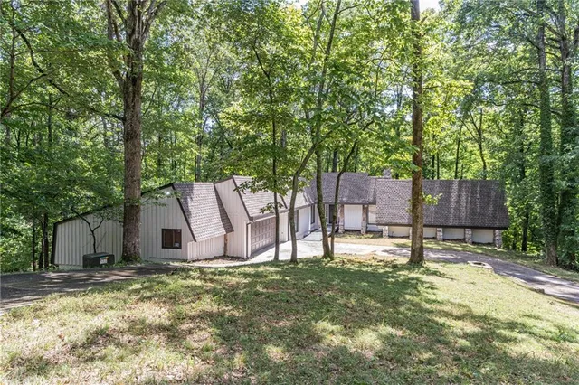 a white house covered with tall trees