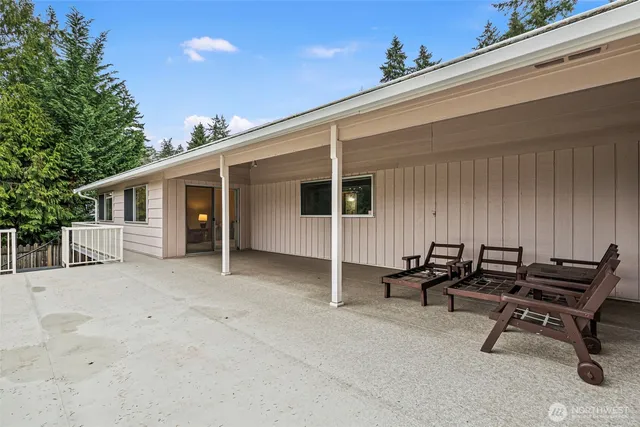 a view of a patio with table and chairs and wooden fence