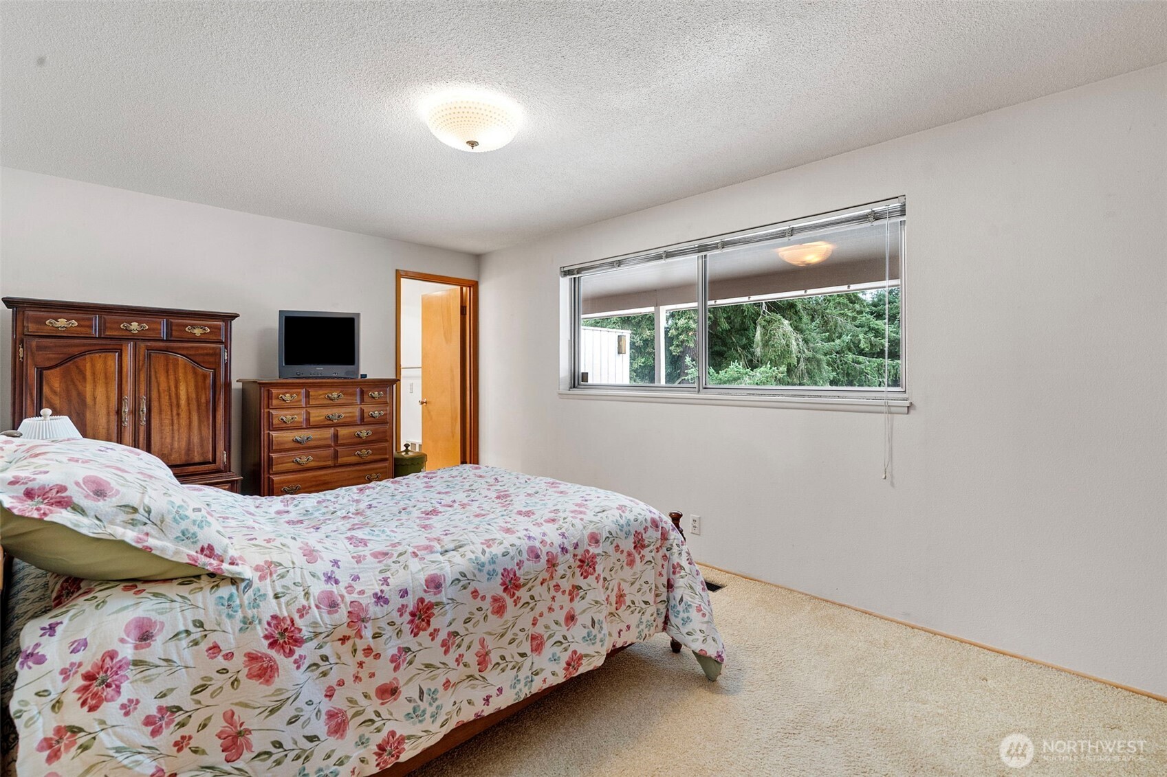 906 Forrest Park Drive Fircrest, WA 98466 - Photo 16 of 37 a bedroom with a bed and a flat tv screen on dresser