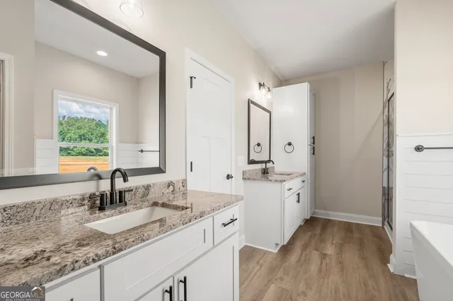 a bathroom with a sink double vanity granite tub and shower