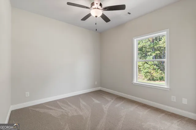 an empty room with a window and a fan