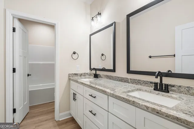 a bathroom with a granite countertop sink and a mirror