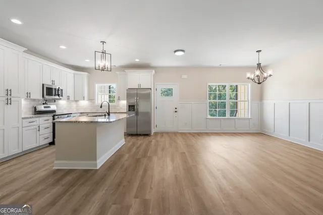 a large kitchen with kitchen island a sink a center island stainless steel appliances and a cabinets