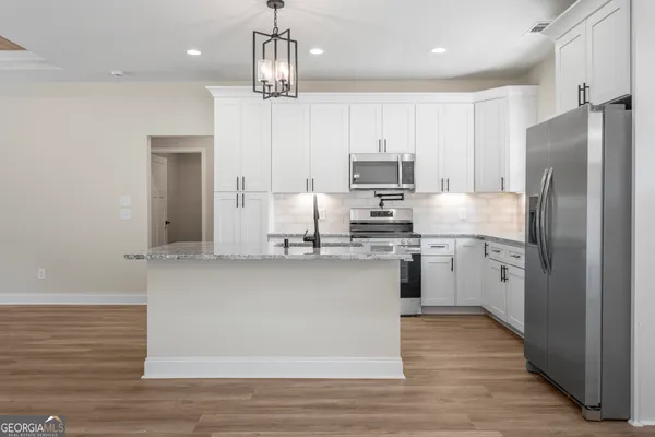 a kitchen with stainless steel appliances a refrigerator sink and microwave