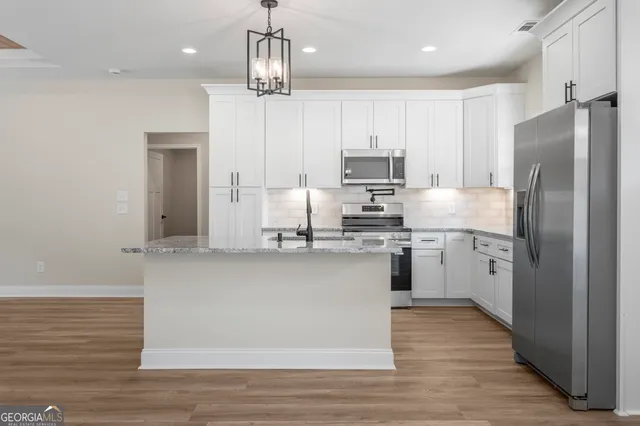 a kitchen with stainless steel appliances a refrigerator sink and microwave