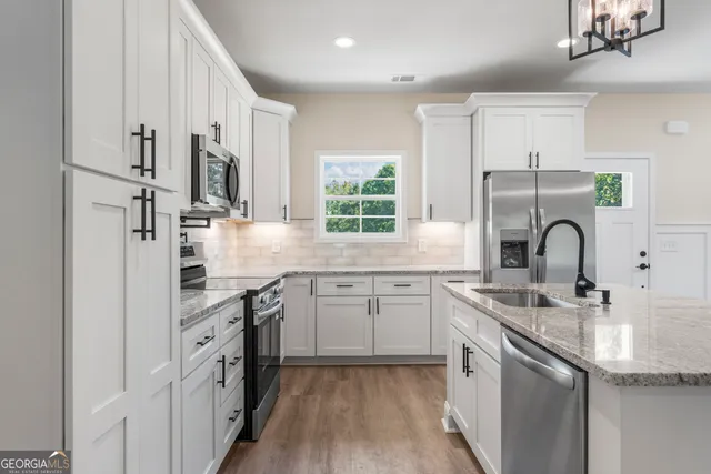 a kitchen with stainless steel appliances granite countertop a sink stove and refrigerator
