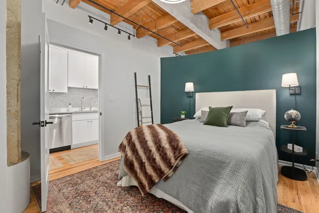 a bedroom with a bed and painting on the wall