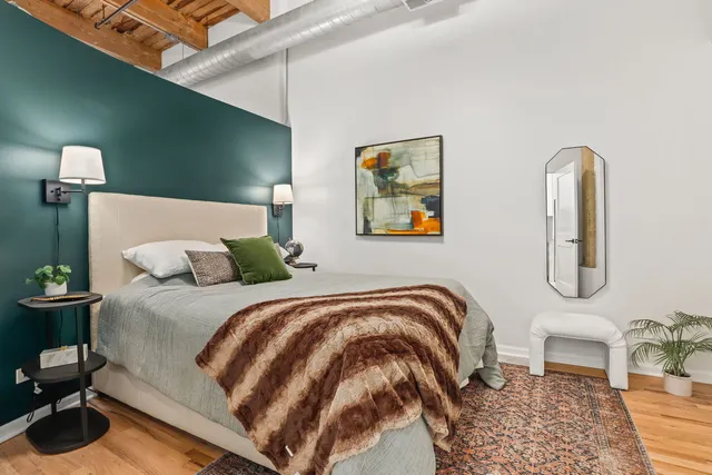 a bedroom with a bed and a painting on the wall