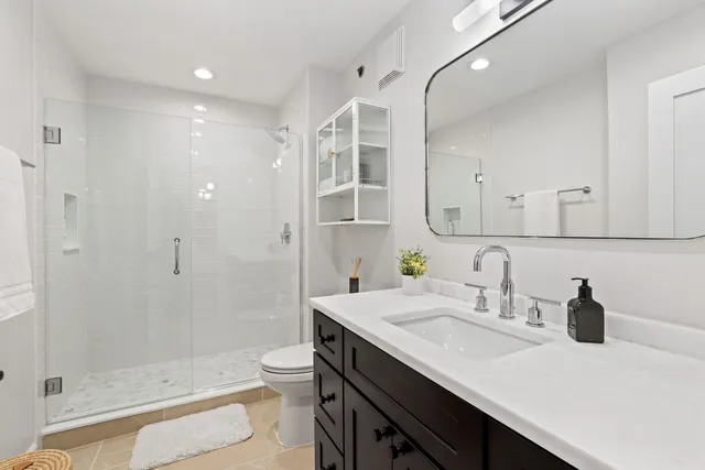 a bathroom with a shower a toilet and a sink