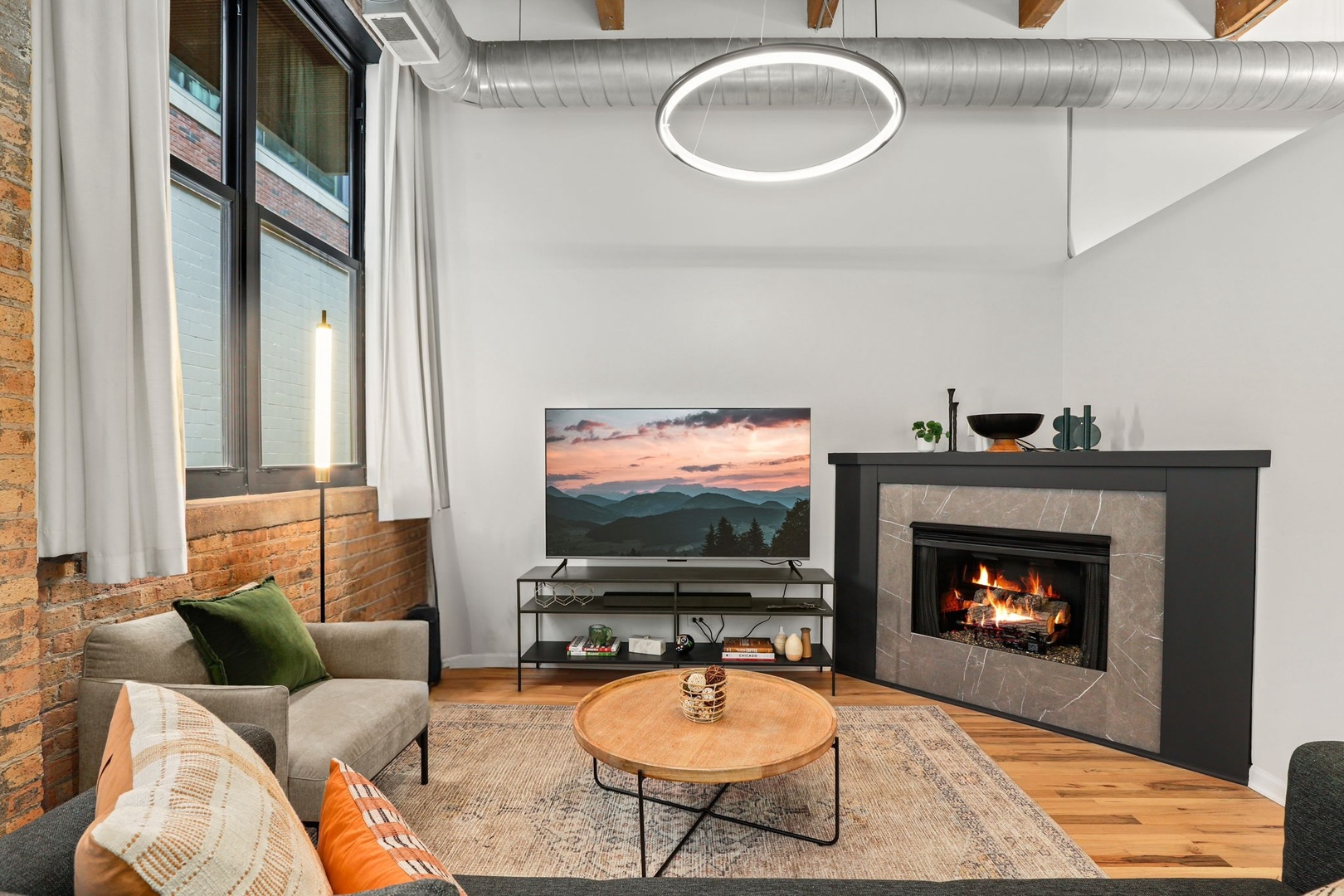 215 North Aberdeen Street, Unit 202B Chicago, IL 60607 - Photo 9 of 19 a living room with furniture a fireplace and a flat screen tv