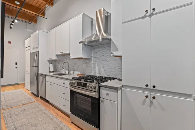 a kitchen with stainless steel appliances a sink stove and cabinets