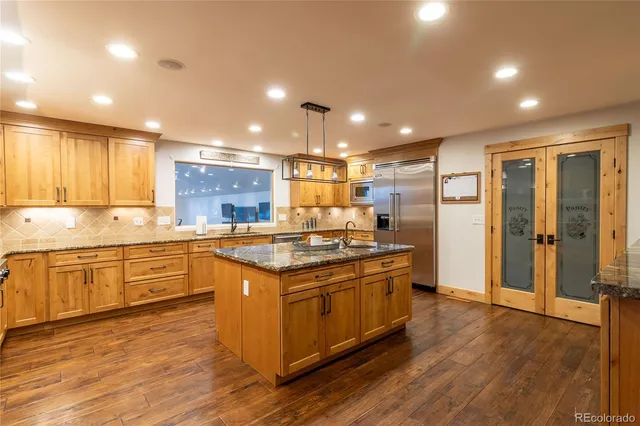 a large kitchen with stainless steel appliances granite countertop a stove and a sink