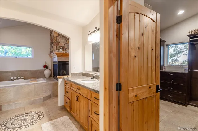 a bathroom with a tub a sink and a large mirror