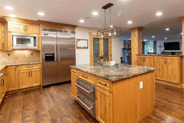 a kitchen with stainless steel appliances granite countertop a sink a stove and a refrigerator