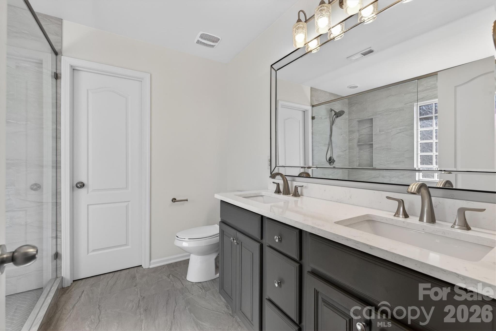 5527 Cactus Valley Road, Unit 183 Charlotte, NC 28277 - Photo 25 of 47 a bathroom with a double vanity sink a toilet and a mirror