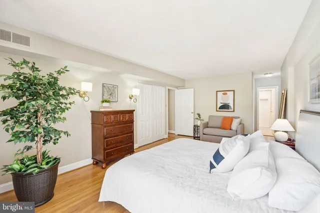 a bedroom with a bed and a potted plant