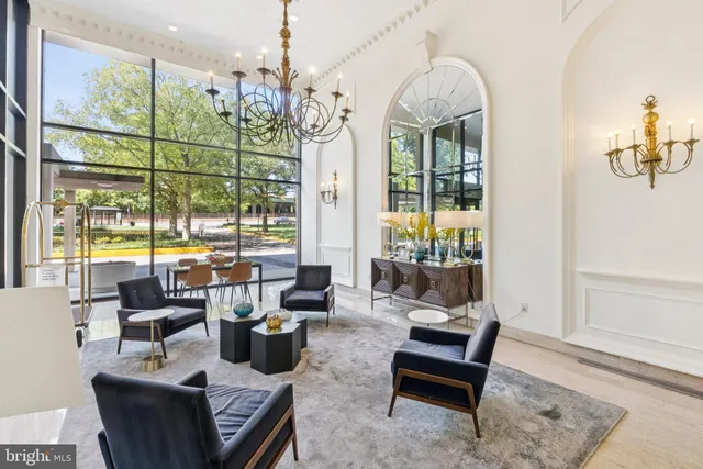 a living room with furniture large windows and wooden floor