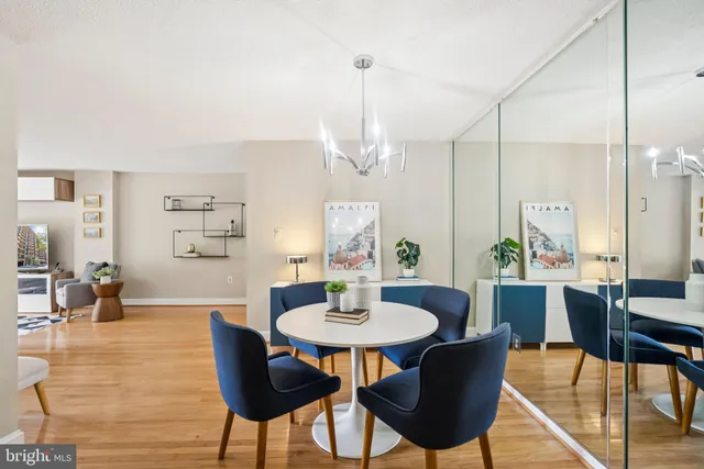 a dining room with furniture a chandelier and wooden floor