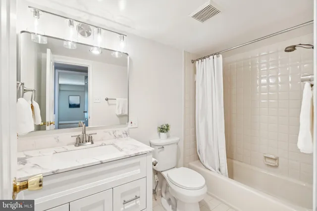 a bathroom with a granite countertop sink a toilet and shower