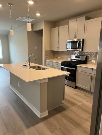 a kitchen with kitchen island granite countertop a sink counter top space and appliances