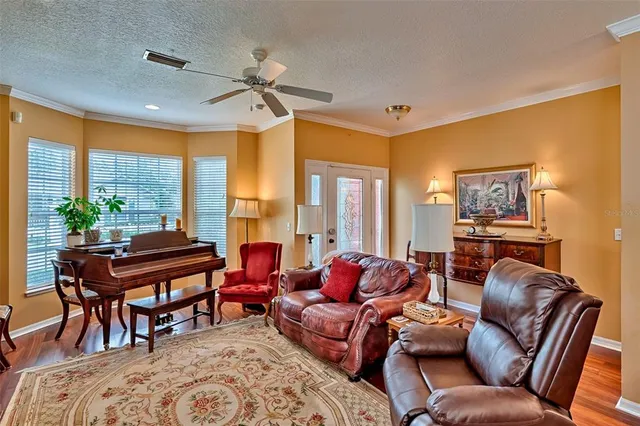 a living room with furniture kitchen view and a wooden floor