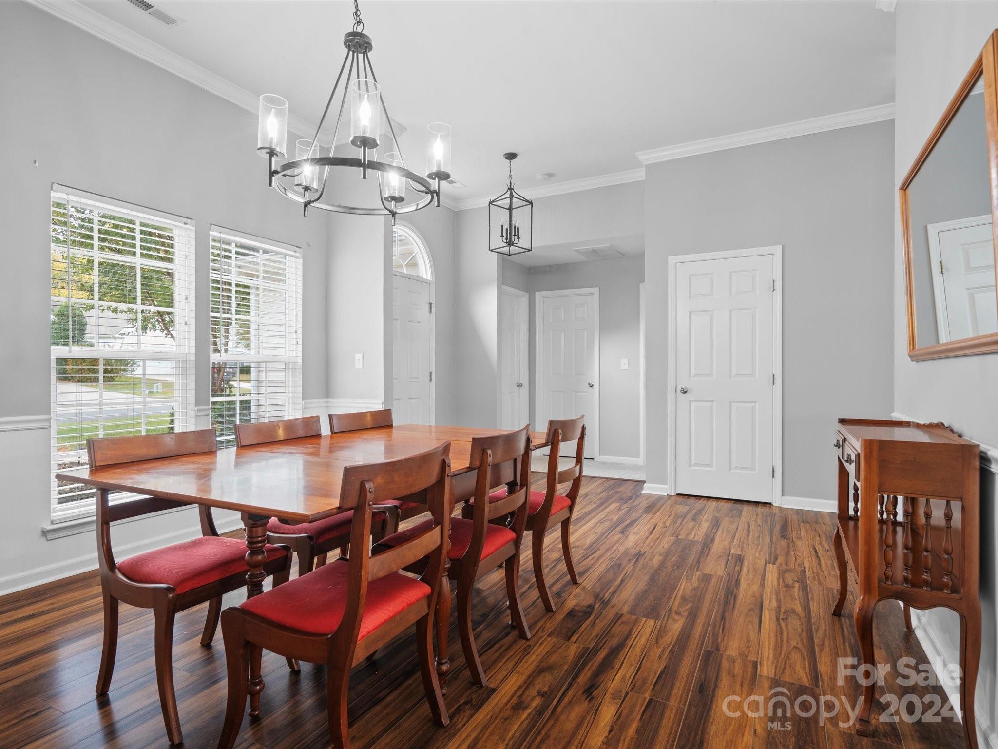 2010 Fairburn Court Fort Mill, SC 29708 - Photo 5 of 39 a dining room with wooden floor a chandelier a wooden table and chairs