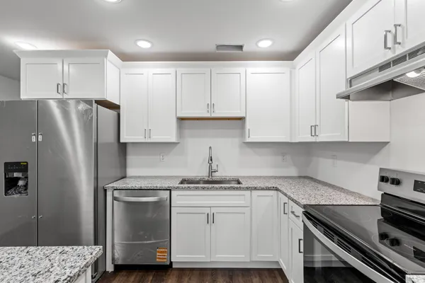 a kitchen with stainless steel appliances white cabinets and a refrigerator