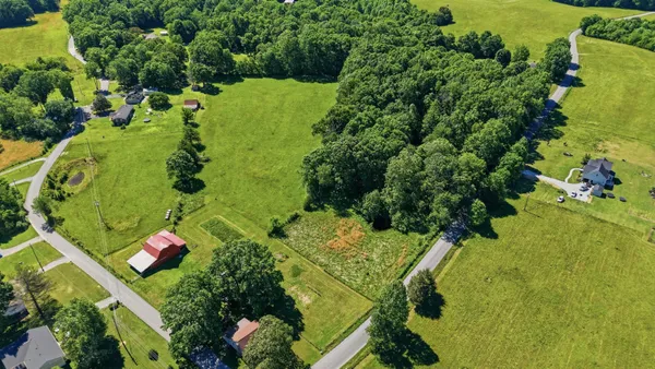 an aerial view of a residential houses with yard